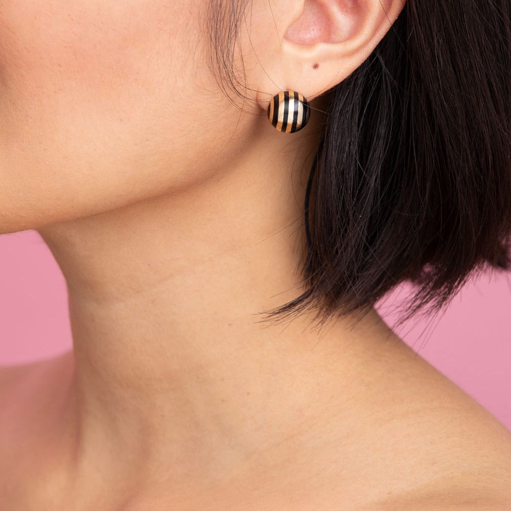 Rachel Quinn Jewelry 14k yellow gold sphere ball earring with black vertical stripes worn on female model ear