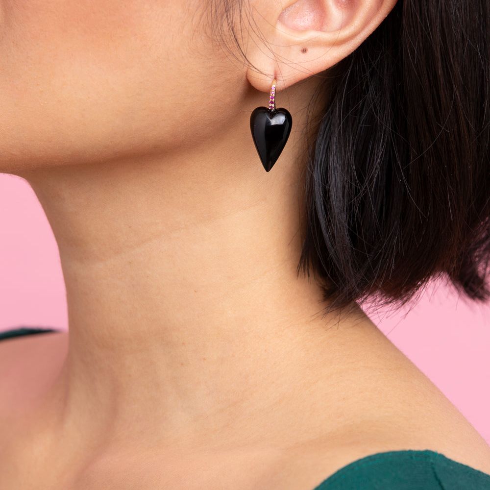 Rachel Quinn Jewelry onyx 3-dimensional heart earring pair magenta sapphires on earring hoop on female model ear.