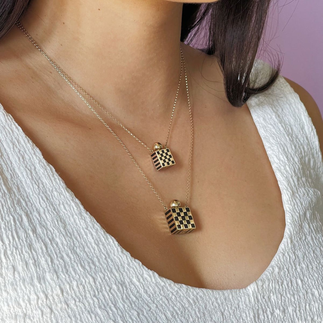 Rachel Quinn Jewelry small and large square 14k yellow gold and black checkered vessel box necklaces on gold chain worn layered on female model neck