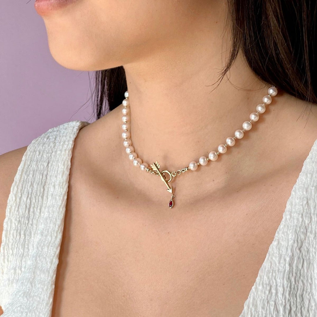 rachel quinn jewelry pearl artemis necklace with yellow gold arrow clasp shown on model neck
