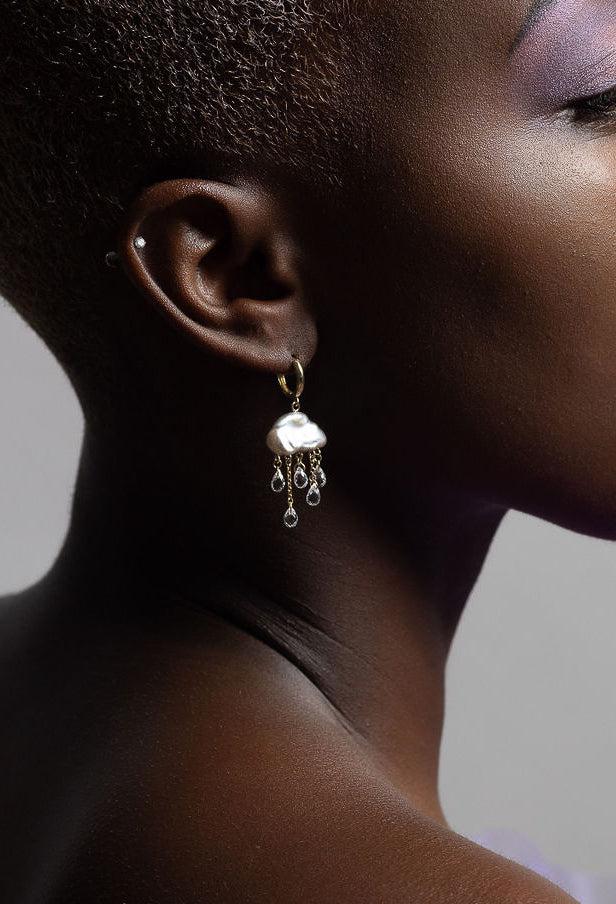 model wearing monsoon huggie hoop looking to the side on a profile