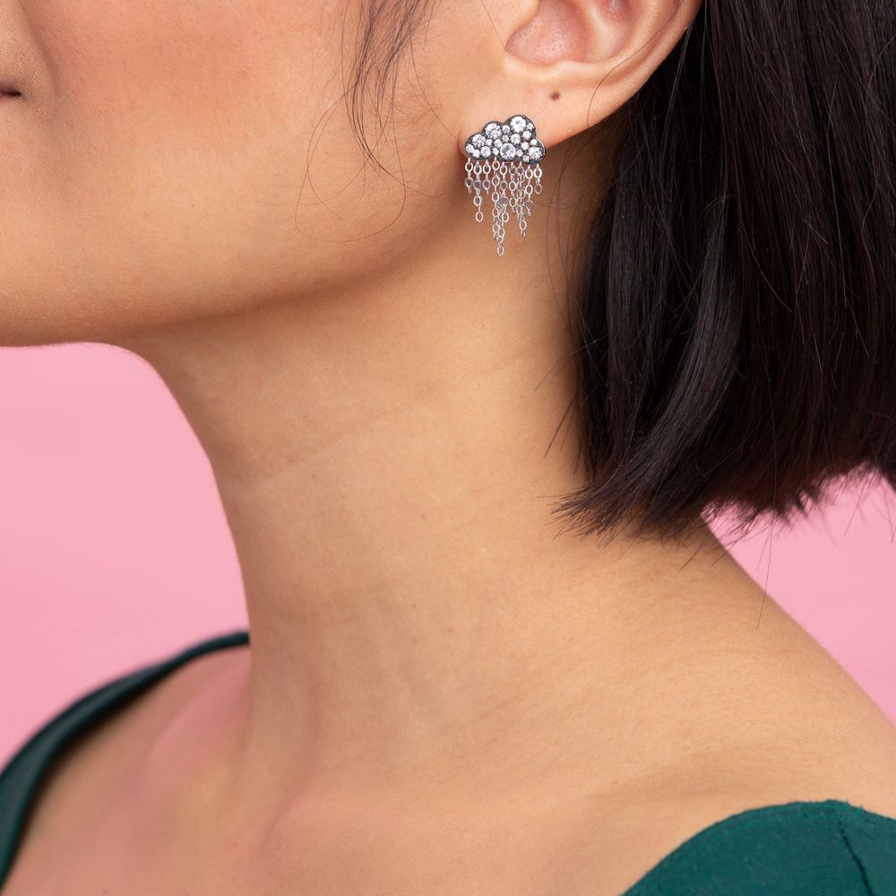 Rachel Quinn Jewelry black cloud shaped earring with pave white sapphires on cloud and dangling chains on female model ear