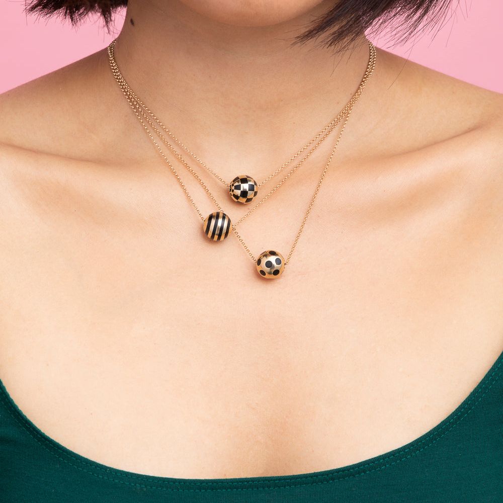 Rachel Quinn Jewelry model wearing 3 sphere gold and black pattern variations necklace on gold chains worn around models neck