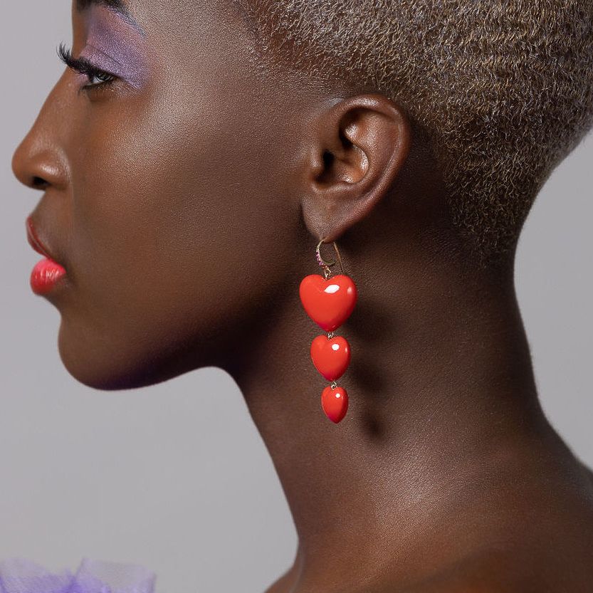 model looking to the side wearing triple heart earrings
