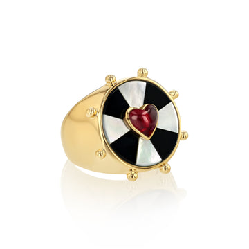 Yellow gold ring with black and white bullseye pattern and a pink heart set in the center