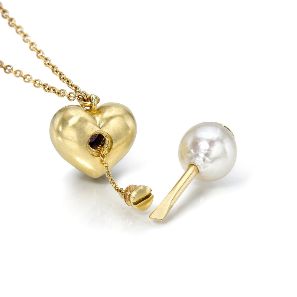 Rachel Quinn Jewelry 14k yellow gold heart shaped vessel necklace on gold chain with single heart ruby in center with pearl screwdriver attachment.