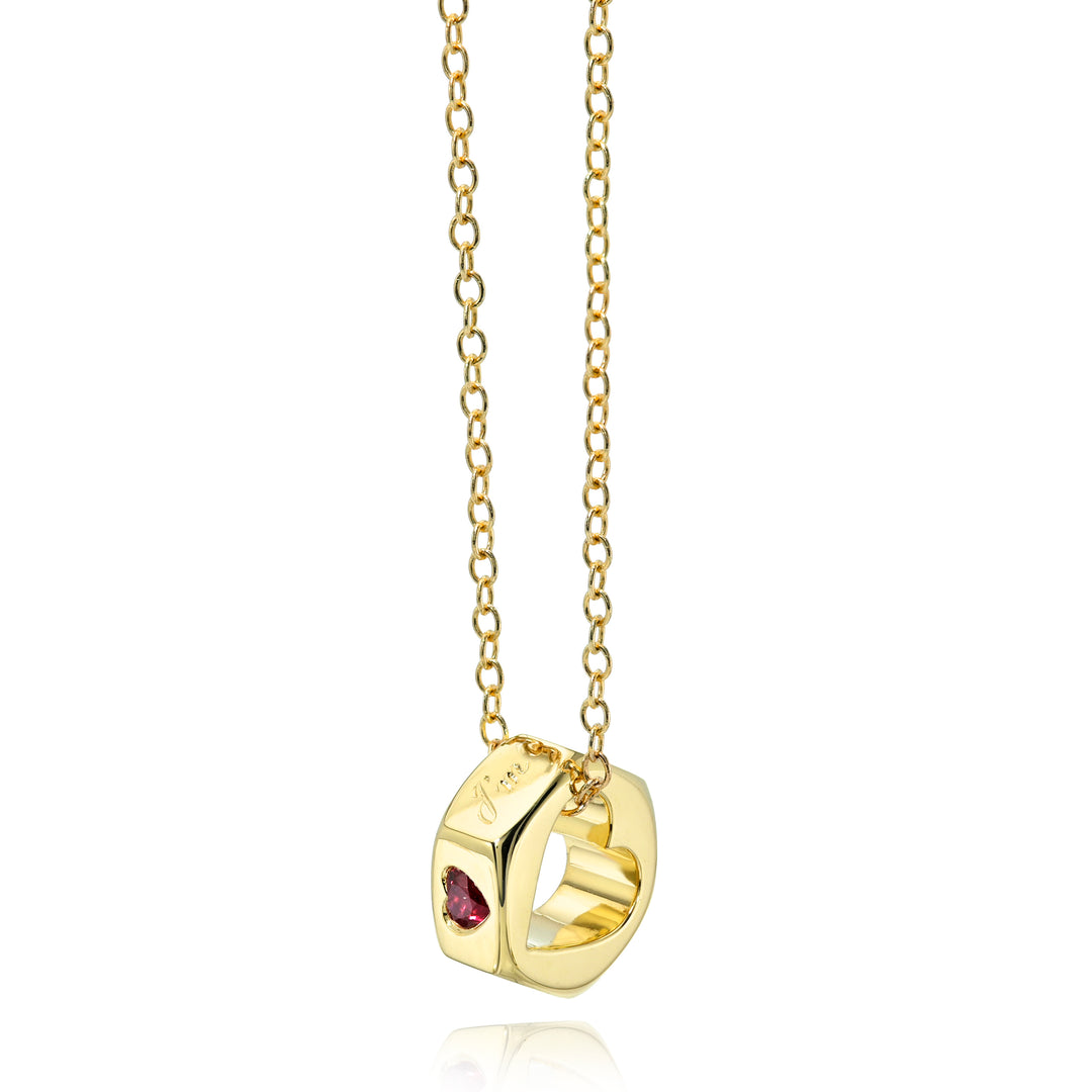 Yellow gold chain necklace with a hex nut pendant with a heart cut out and, engraving, and ruby heart stone on a white background