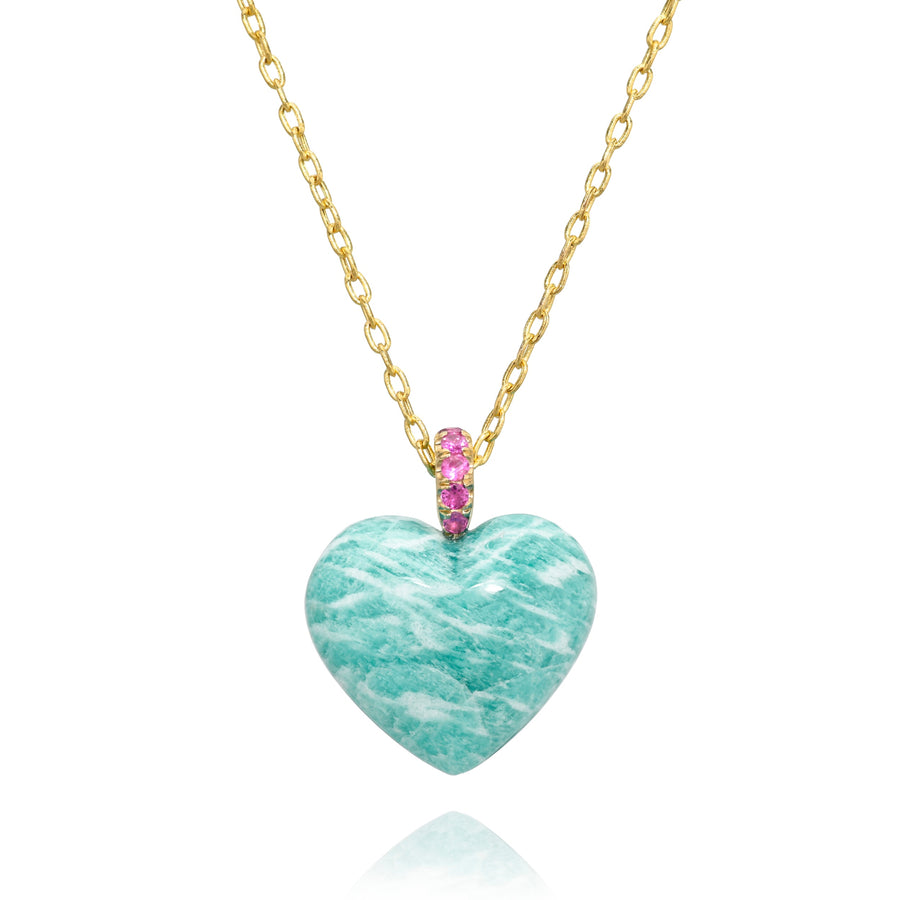Heart-shaped blue with white streaks stone pendant on a gold chain with a pink gemstones bail against a white background