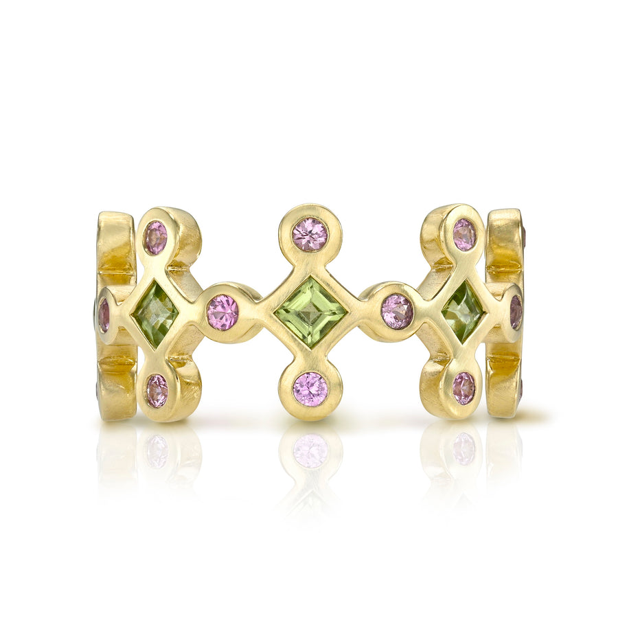 Yellow gold ring with green and pink gemstones on a white background