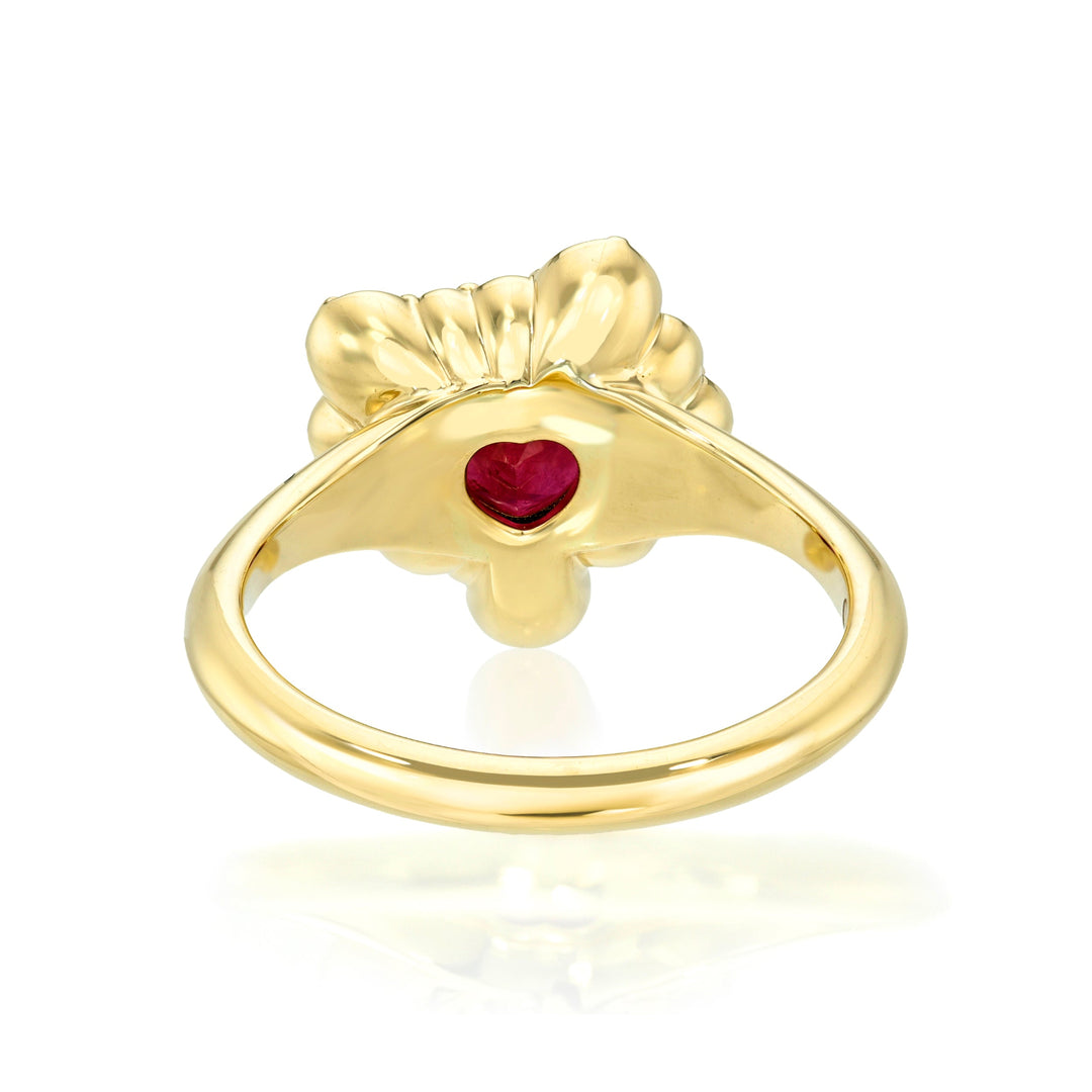 Back view of a gold ring with a red gemstone on a white background
