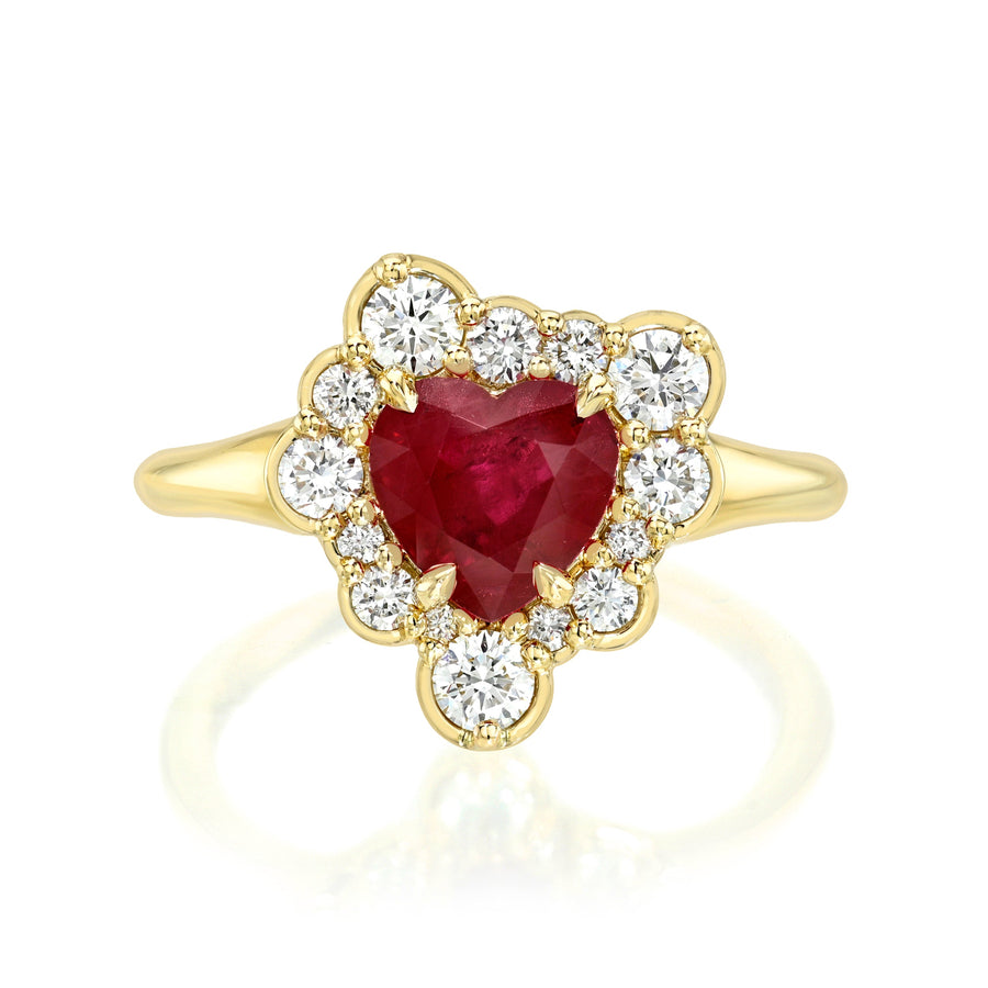 Gold ring with a heart-shaped ruby and diamond accents on a white background