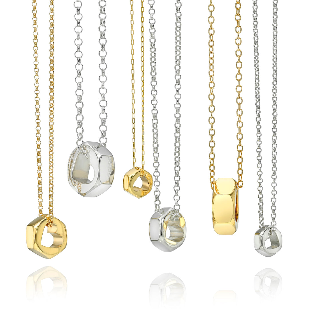 Gold and silver chain necklaces with hex nut pendant hanging down, on a white background