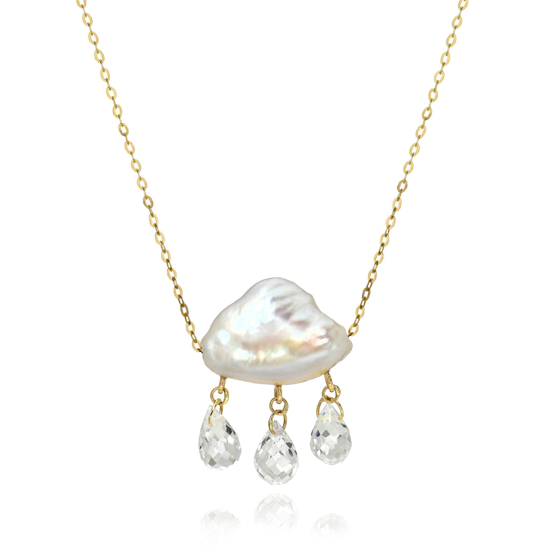 Necklace with a white keshi pearl pendant and smaller briolettes droplets dangling below on a gold chain against a white background.