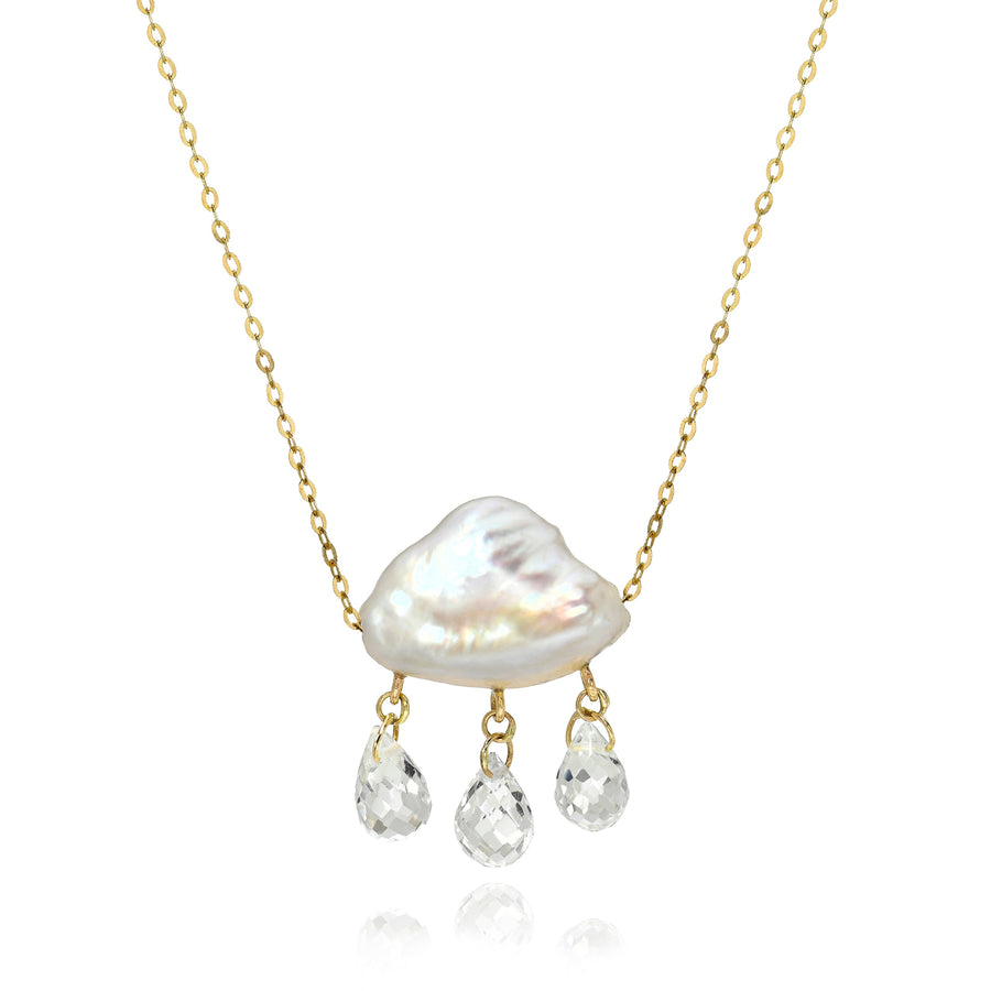 Necklace with a white keshi pearl pendant and smaller briolettes droplets dangling below on a gold chain against a white background.