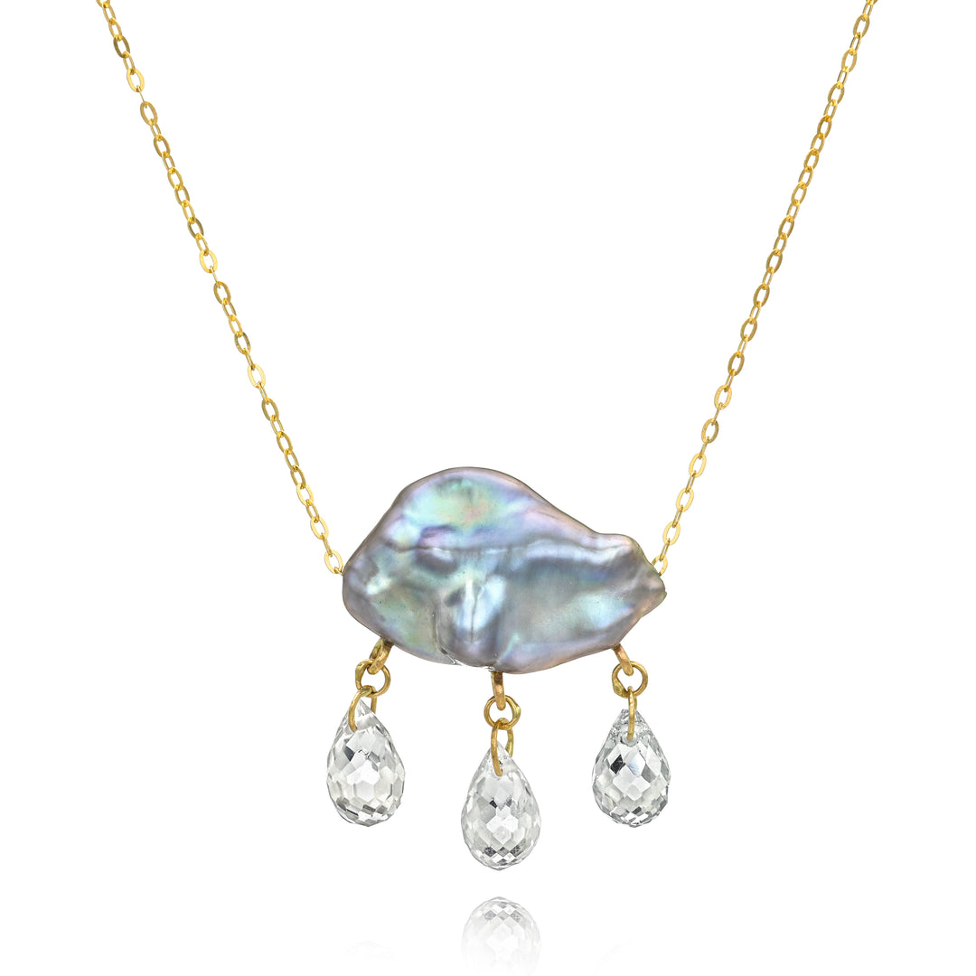 Necklace with a grey keshi pearl pendant on a gold chain with three teardrop-shaped gemstones dangling below on a white background