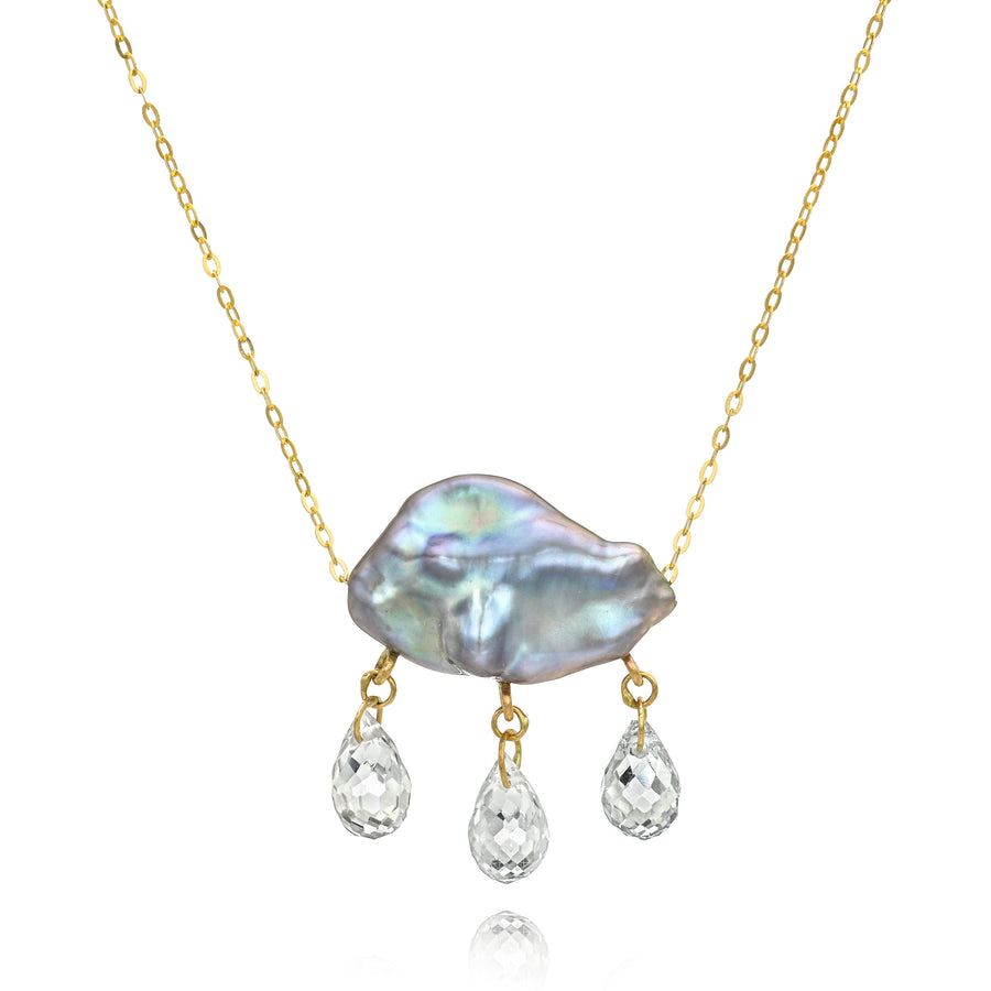 Necklace with a grey keshi pearl pendant on a gold chain with three teardrop-shaped gemstones dangling below on a white background
