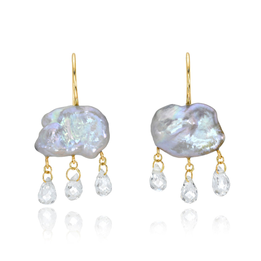Pair of earrings with grey keshi pearl drops and smaller teardrop briolettes on gold hooks against a white background.