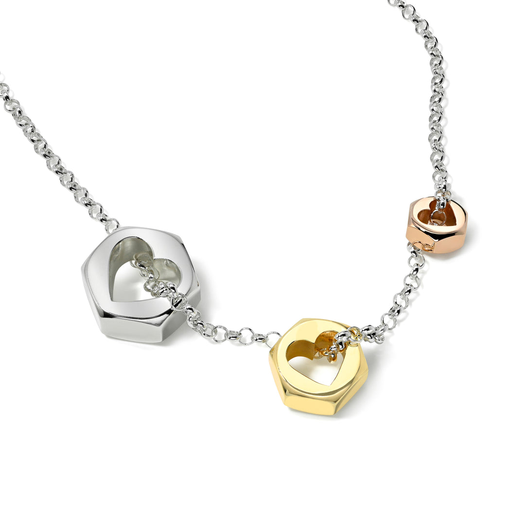 Silver chain necklace with 3 hex nut pendants with center heart cut outs in silver and yellow and rose gold on a white background