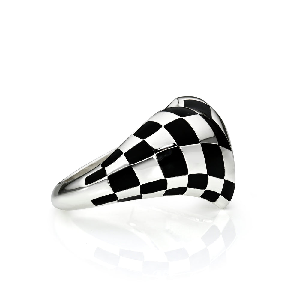 Side view of black checkered silver heart ring on a white background