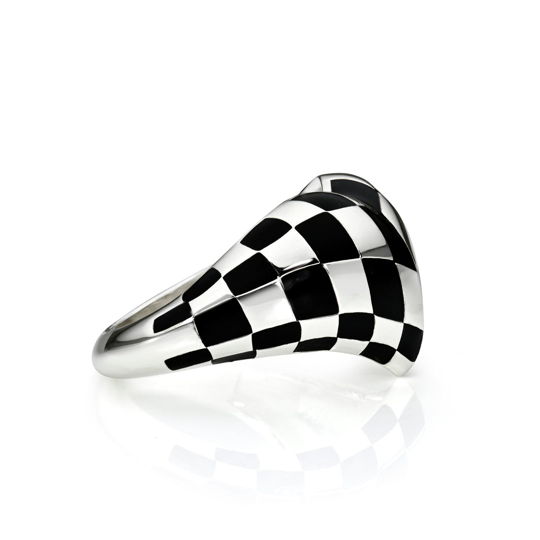 Side view of black checkered silver heart ring on a white background