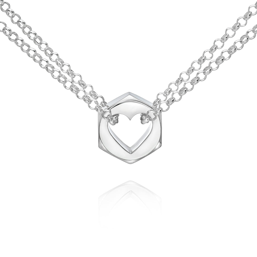 Close up of a silver hex nut pendant with silver chains holding it from either side on a white background