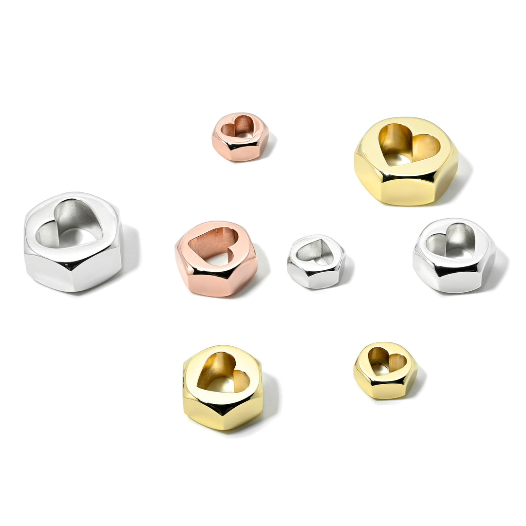 Hex nut charms in 3 sizes with a center heart-shaped opening in yellow and rose gold, and silver on a white background