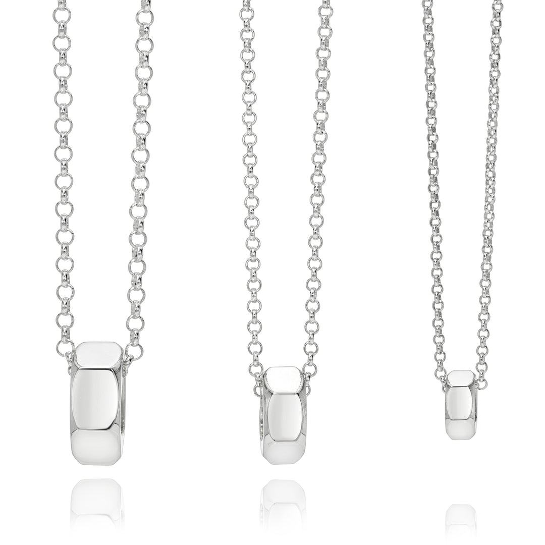 Three silver necklaces with pendant attachments on a white background