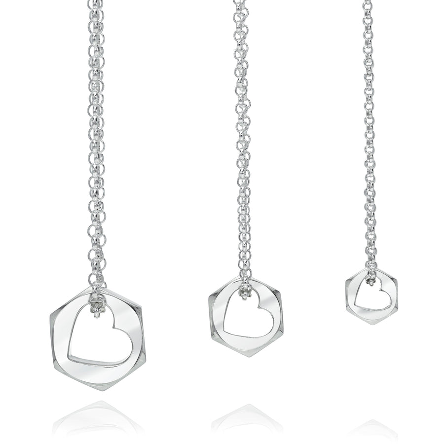 Silver necklace with hex nut shape pendant with a heart shaped opening on a white background