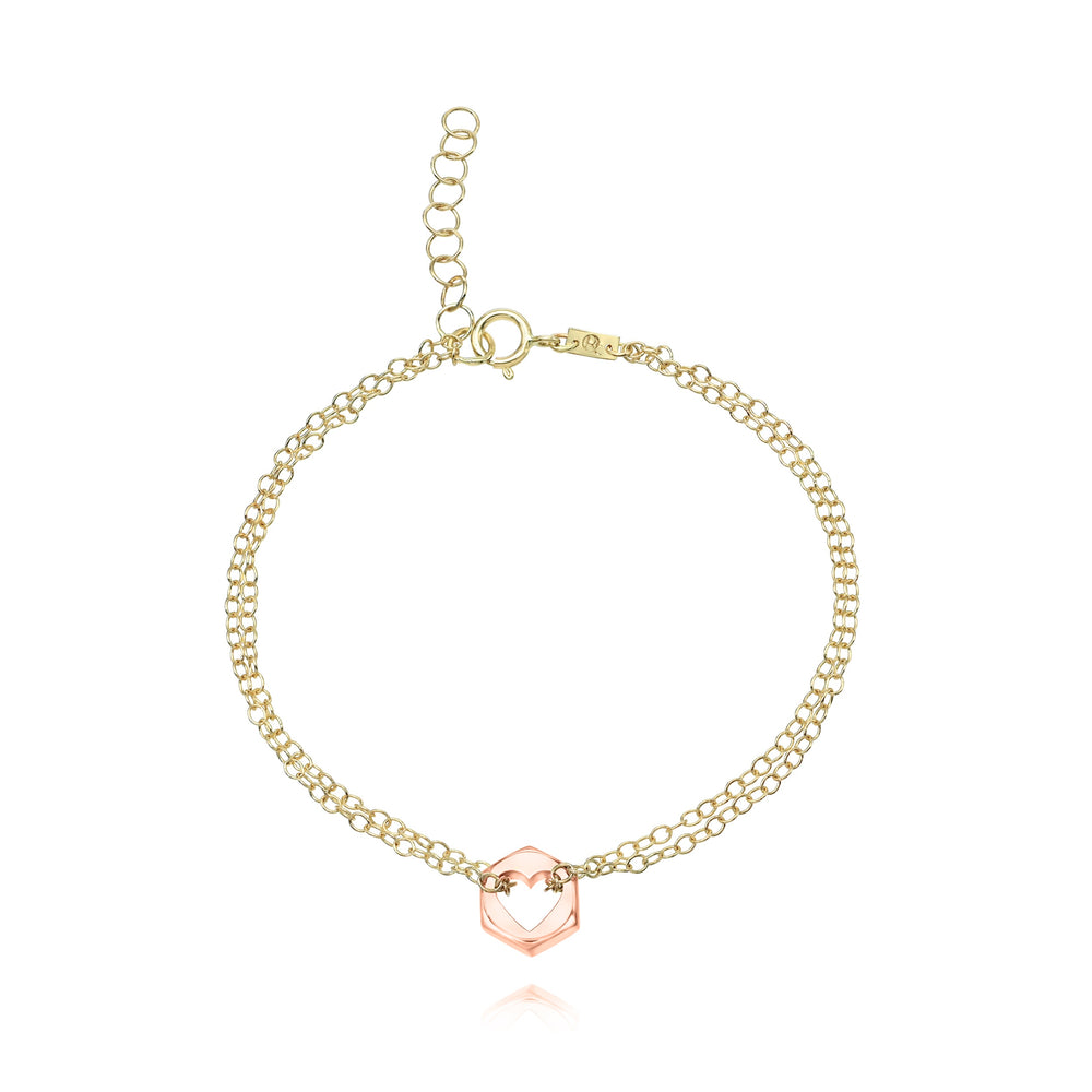 Yellow gold bracelet with a rose gold hex nut charm with a heart cut in the center on a white background