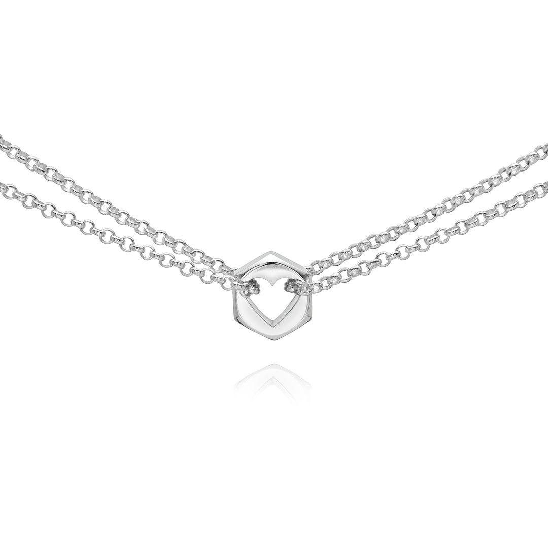 Close up of a silver hex nut charm with silver chains holding it from either side on a white background