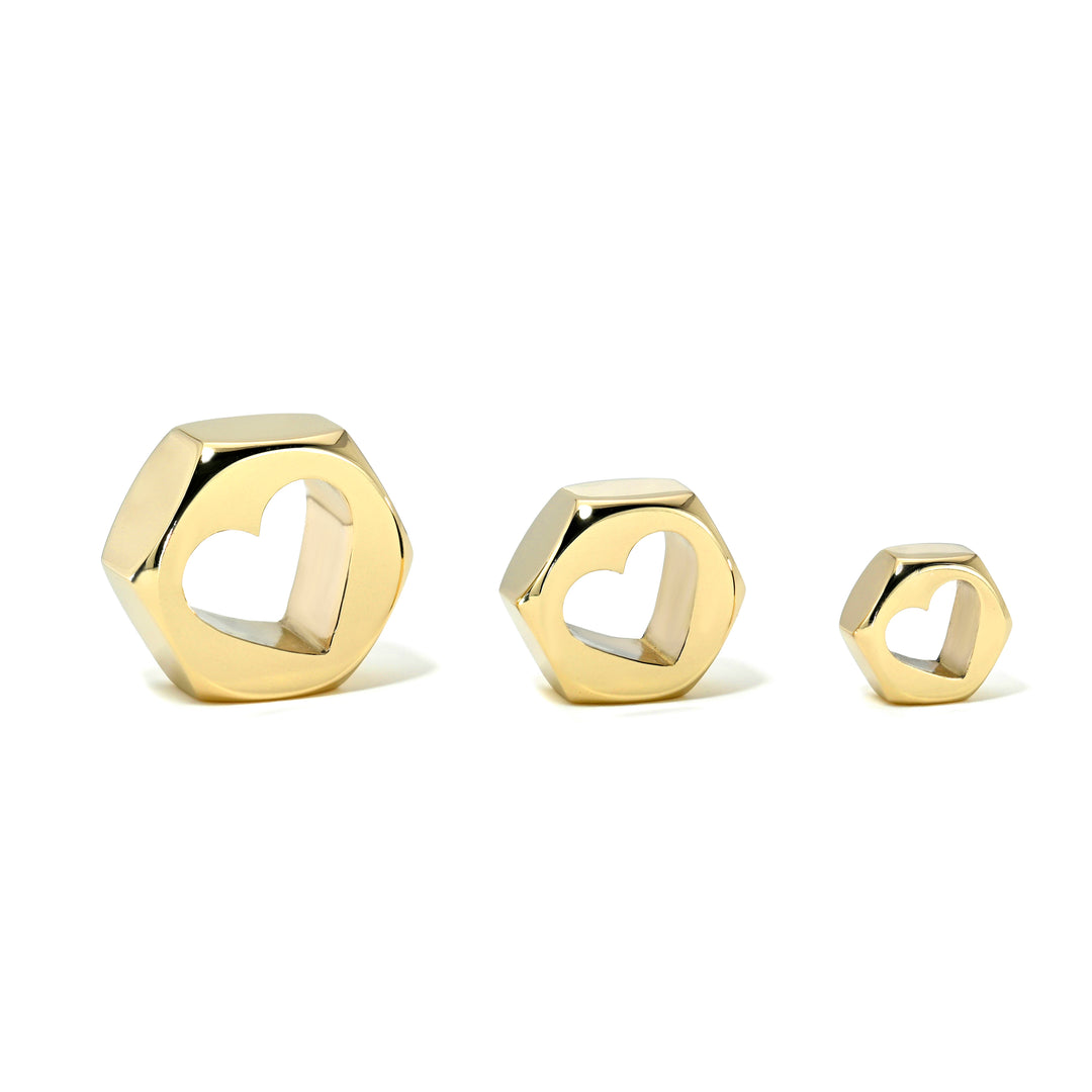Set of three yellow gold hex nut charms in sizes large, medium, and small with heart-shaped center holes on a white background