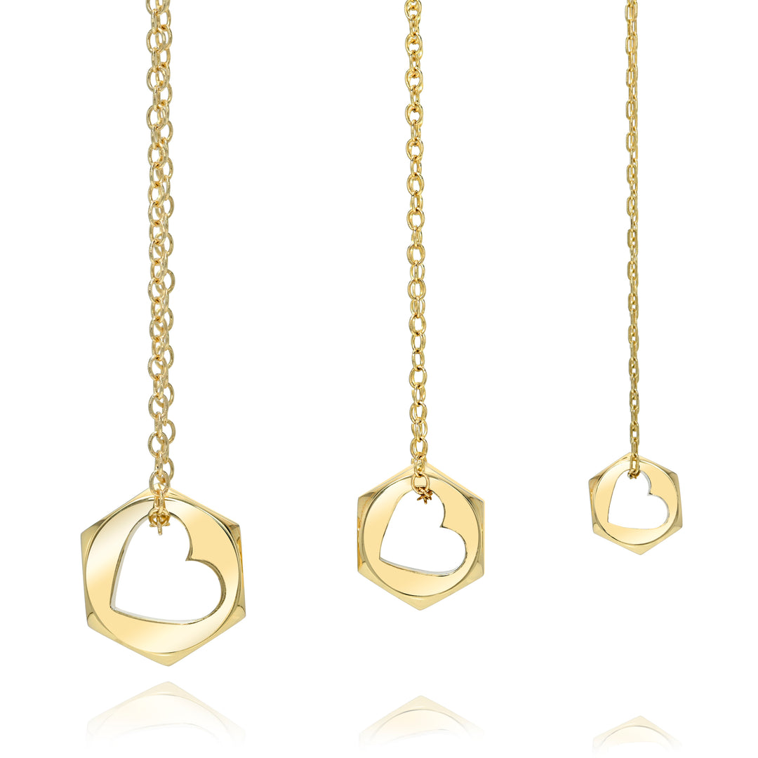 Three gold chain necklaces in three sizes with hex nut heart cut out pendants on a white background