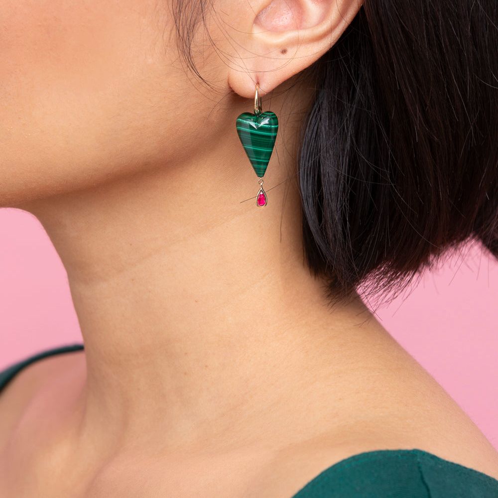 Rachel Quinn Jewelry hand-carved malachite heart earring topped with 14K yellow ear wires with a bezel-set ruby droplet on female model ear