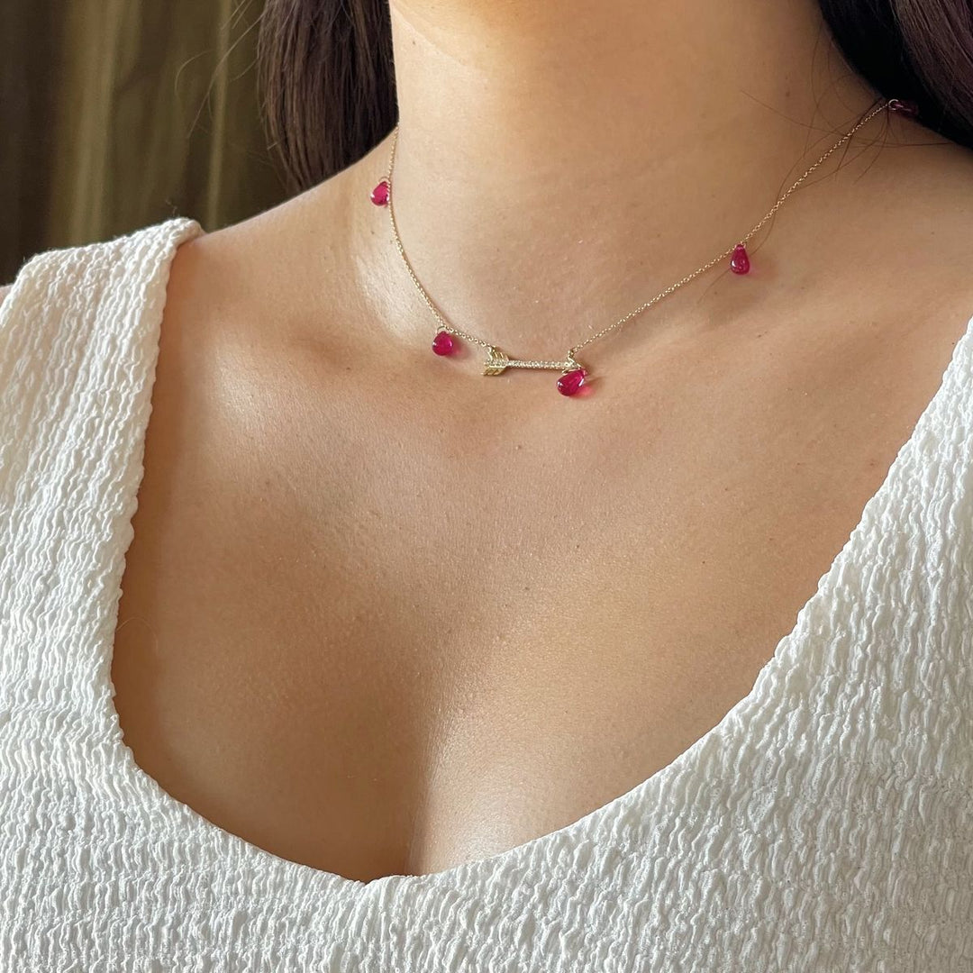 Rachel-Quinn-Jewelry-Artemis-necklace-with-arrow-and-ruby-droplets-shown-on-model-neck-with-white-blouse