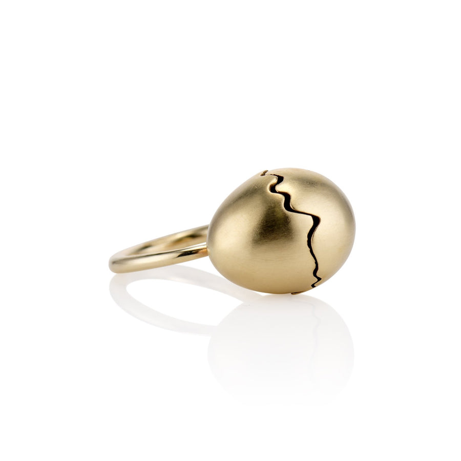 Yellow gold broken egg ring laying on its side