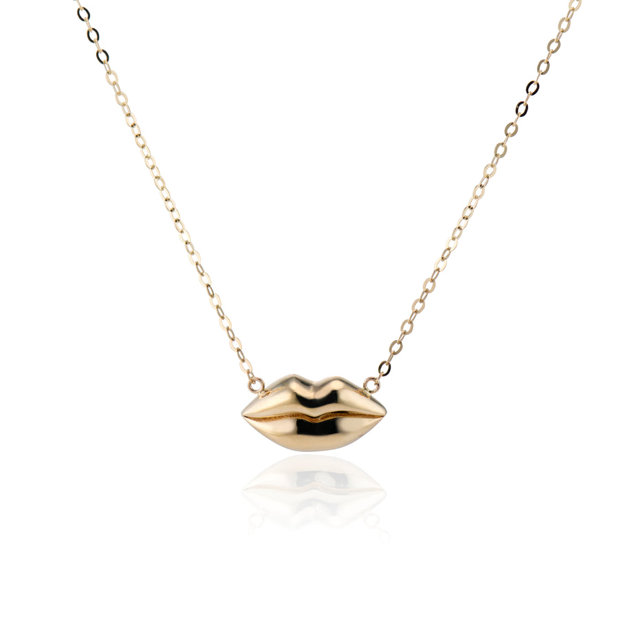 gold lips on a gold chain necklace with a white background