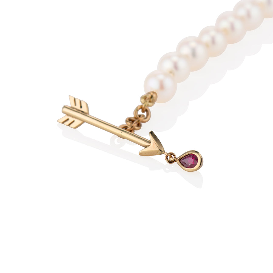 zoomed in shot of the arrow closure on the bracelet with the red ruby bezel on a white background