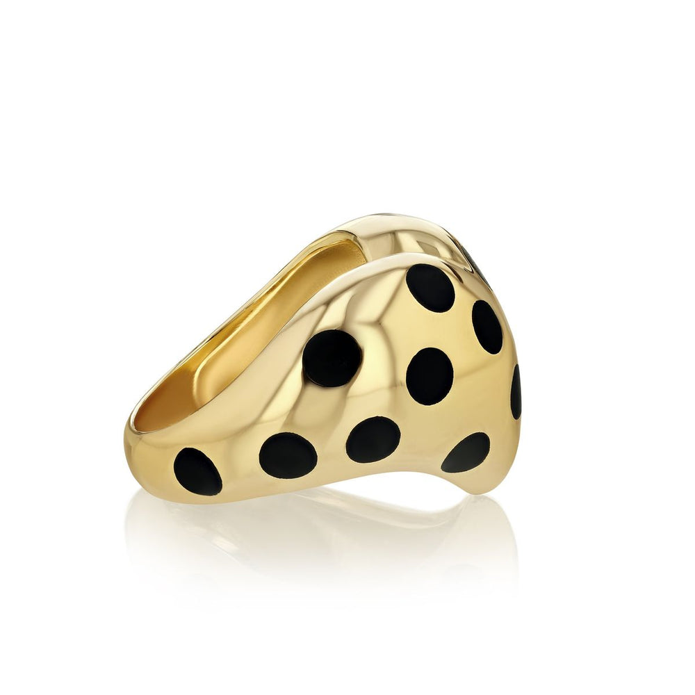 zoomed in side view of gold chubby heart ring with black polka dots on a white background