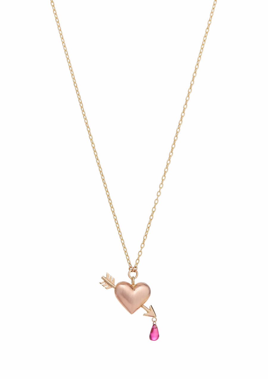 Small rose and yellow gold puffy heart with an arrow piercing it diagonally with a pink ruby droplet dangling from it's tip pendant on a delicate yellow gold chain