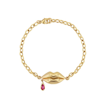 Yellow gold lips with a single droplet of ruby blood dangling from corner of mouth on a gold chain-link bracelet 