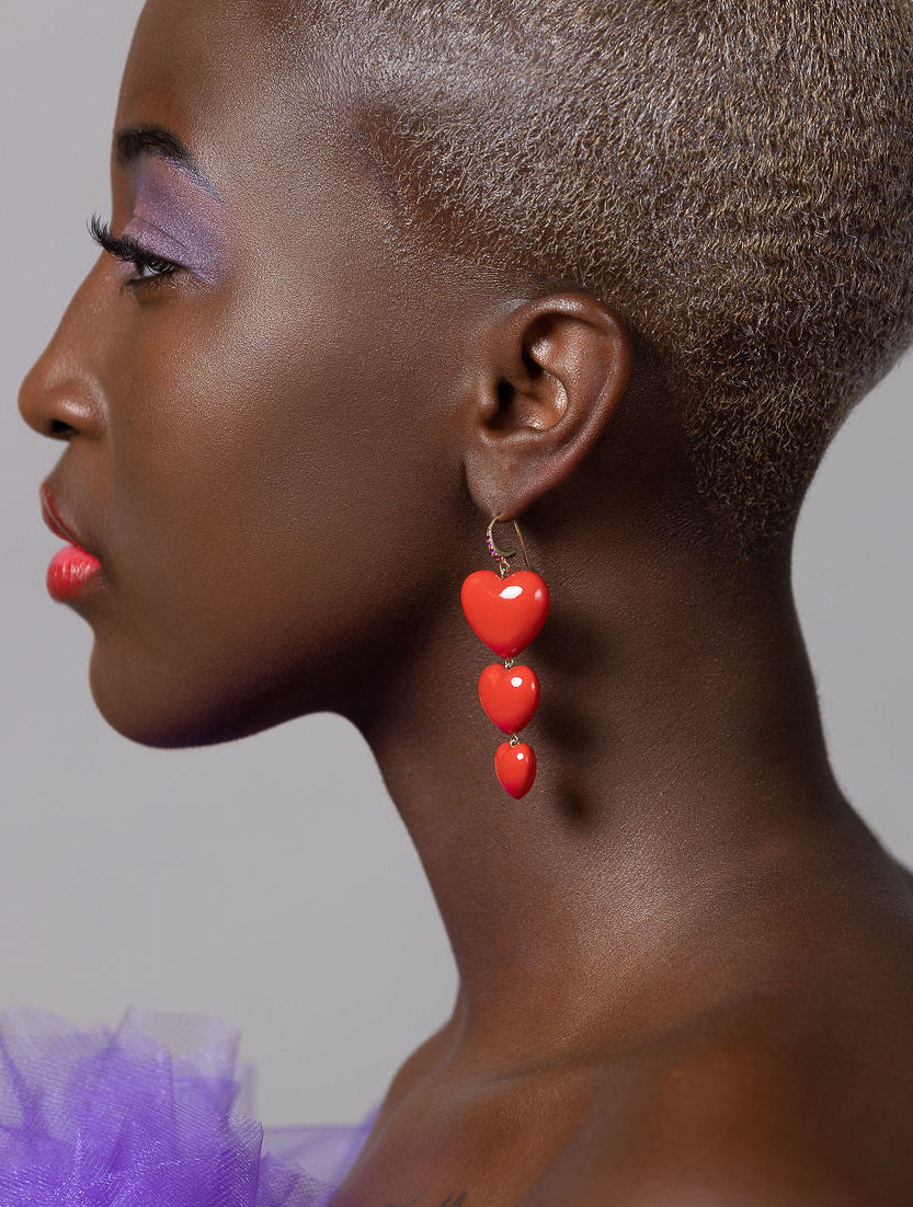 model looking to the side wearing triple heart earrings