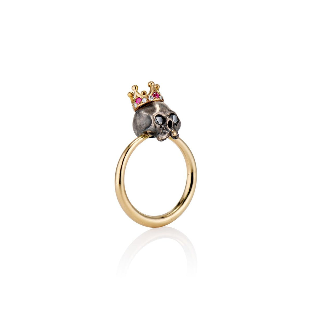 gold ring with blackened royal skull head with gold tooth adorning a ruby and diamond crown side view