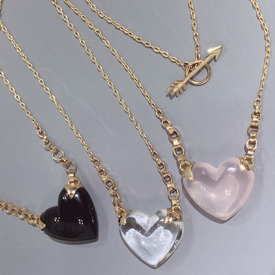 rose shiny puffy quartz heart necklace with side gold shackles leading up to gold chain, along with two other versions of this necklace in clear quartz and black onyx