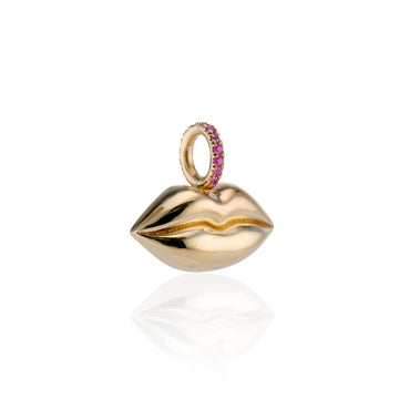 angled shot of gold lips charm with rubies on barrel on a white background