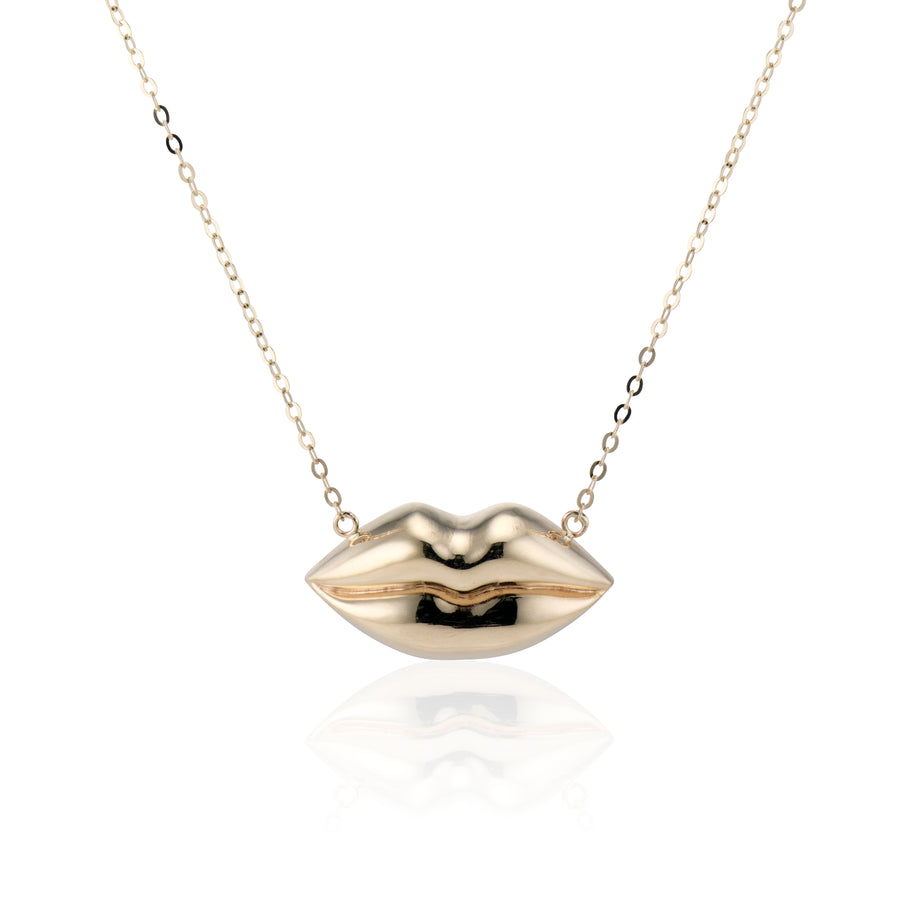 gold lips on a gold chain necklace on a white background