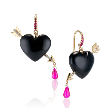 Glossy rich onyx heart earrings are pierced with solid gold arrows, leaving a drop of ruby blood dripping from their tips with pave set diamonds in arrow and rubies in ear wire