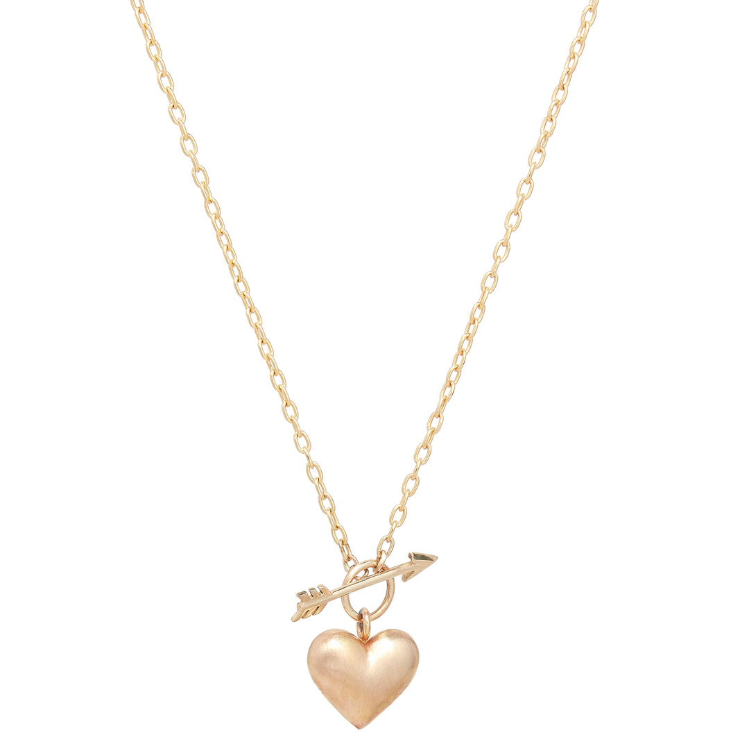 Small yellow gold puffed heart pendant on a chain link necklace with a front arrow toggle clasp