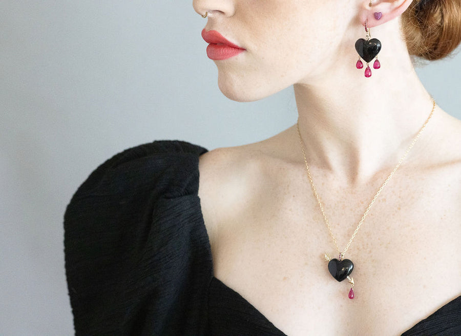 model wearing black heart earrings and black heart necklace