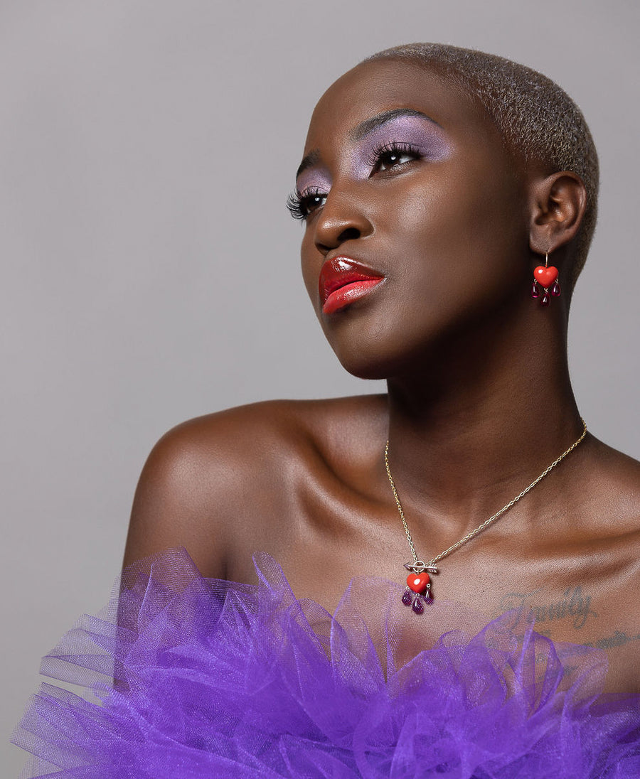 model wearing coral bleeding heart necklace and matching earrings